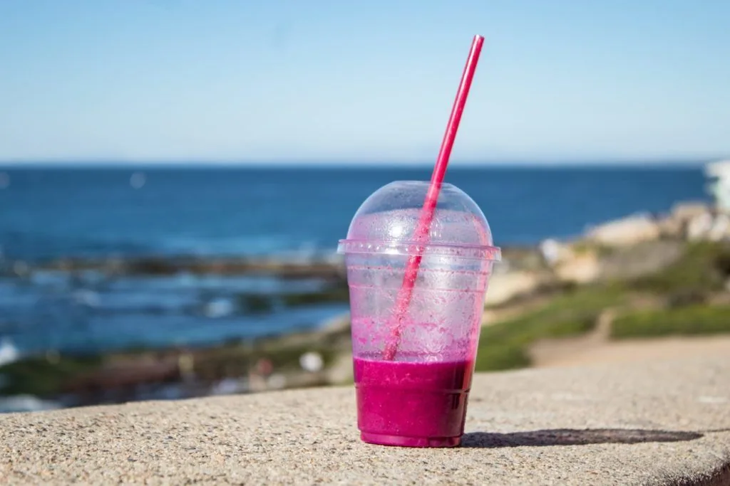 Plastic cup with a drink and a plastic straw