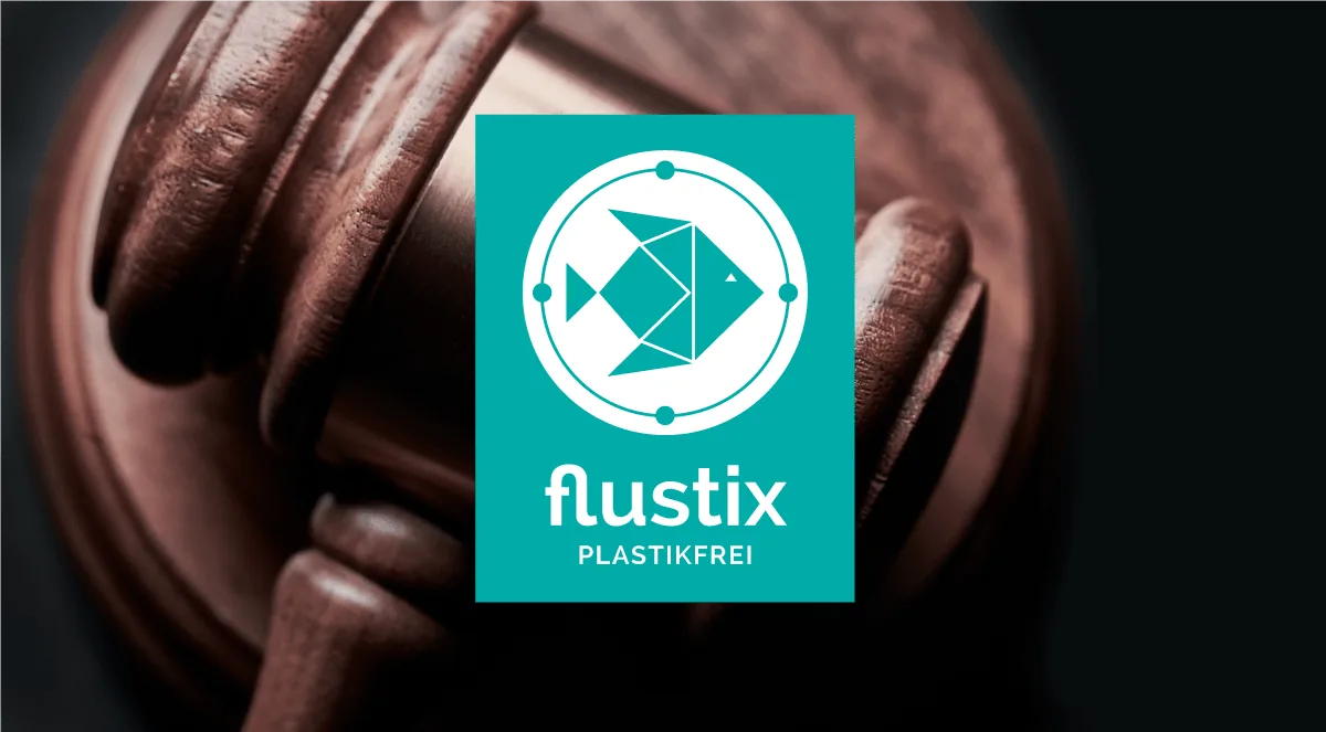 Logo des Flustix-Plastikfrei-Siegel, Hintergrund bildet ein Gerichts Hammer ab, Eigendeklaration Plastikfrei