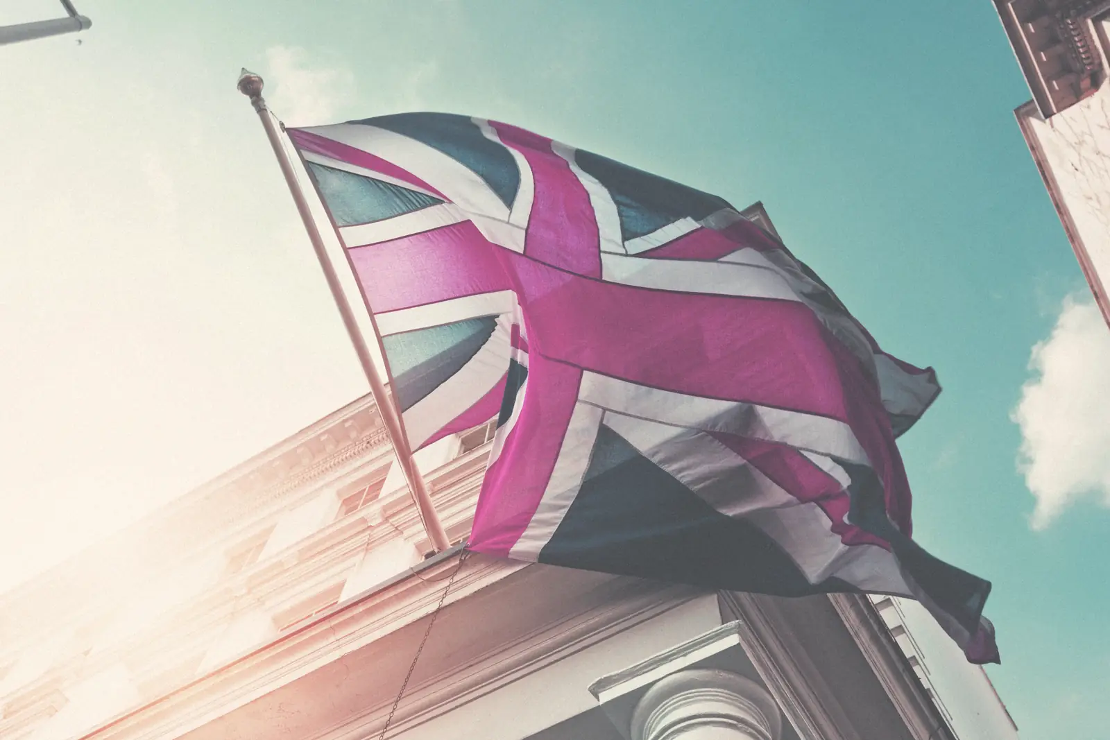 The Union Jack flying in front of a light coloured building