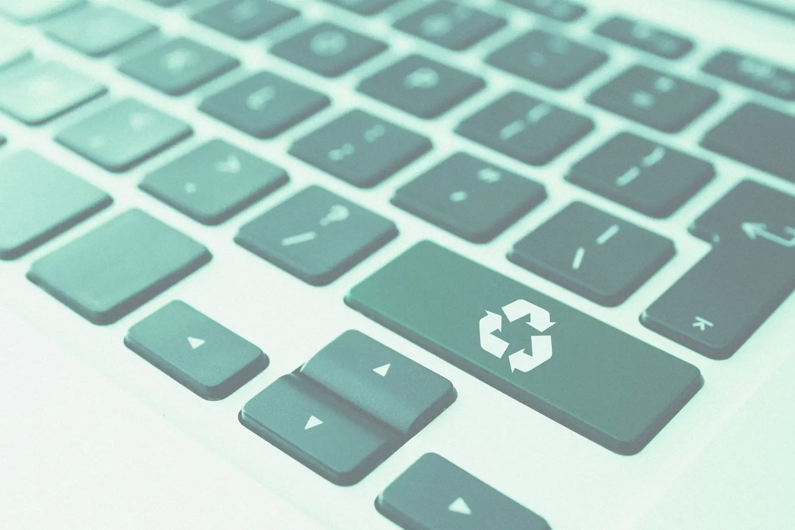 Close-up of a keyboard with the recycling symbol printed on one of the keys